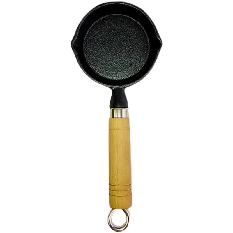 Mit Öl bespritzte Nudeln, Löffel, heißer Topf, Mini-Gusseisen, gekochtes Öl, mit Öl befleckter kleiner Eisentopf